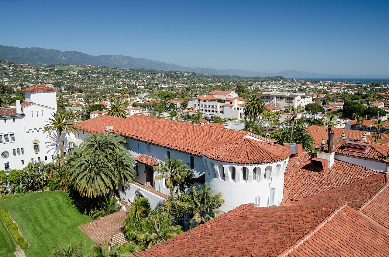 Red-tiled courthouse roofs, gardens and mountains seen from the Santa Barbara courthouse tower