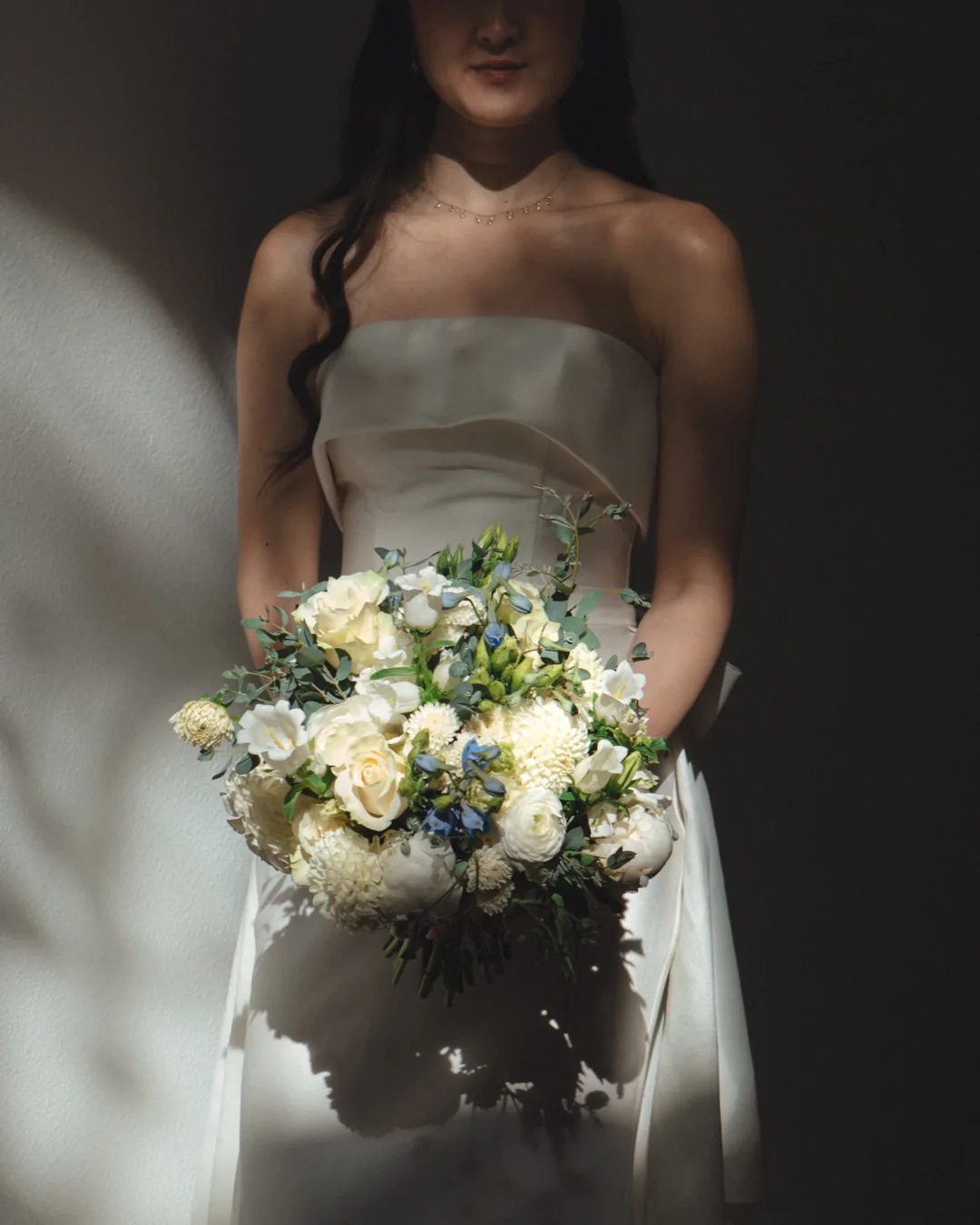 Bride holding a white and pale blue bouquet