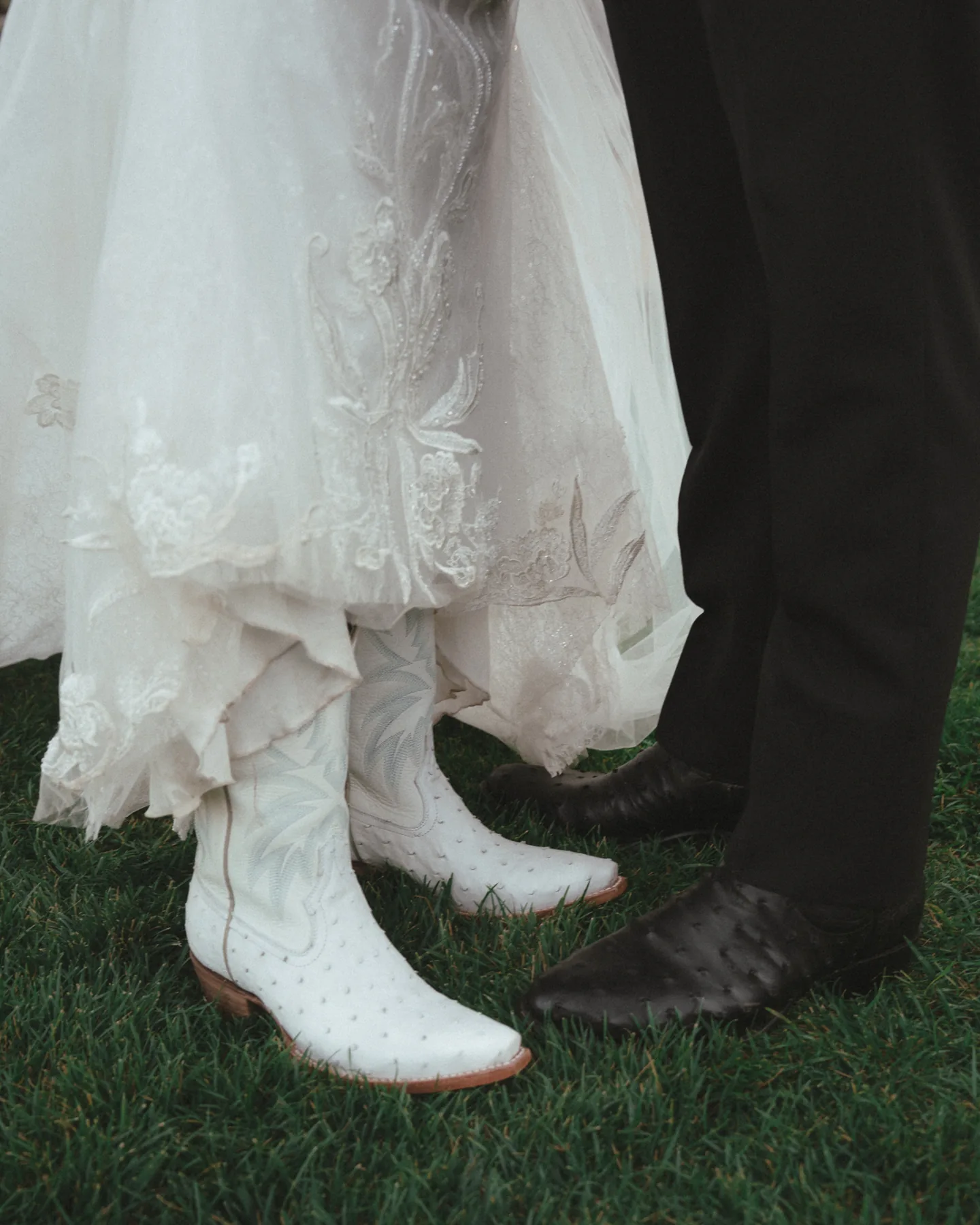 Wedding dress and boots beside a dark suit