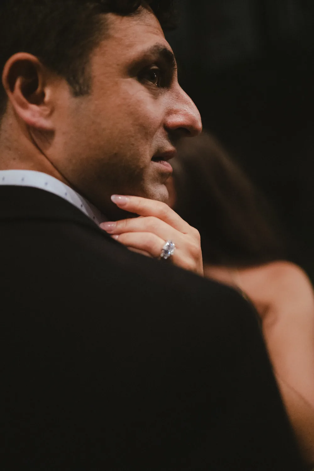 Close portrait of a groom embracing his partner