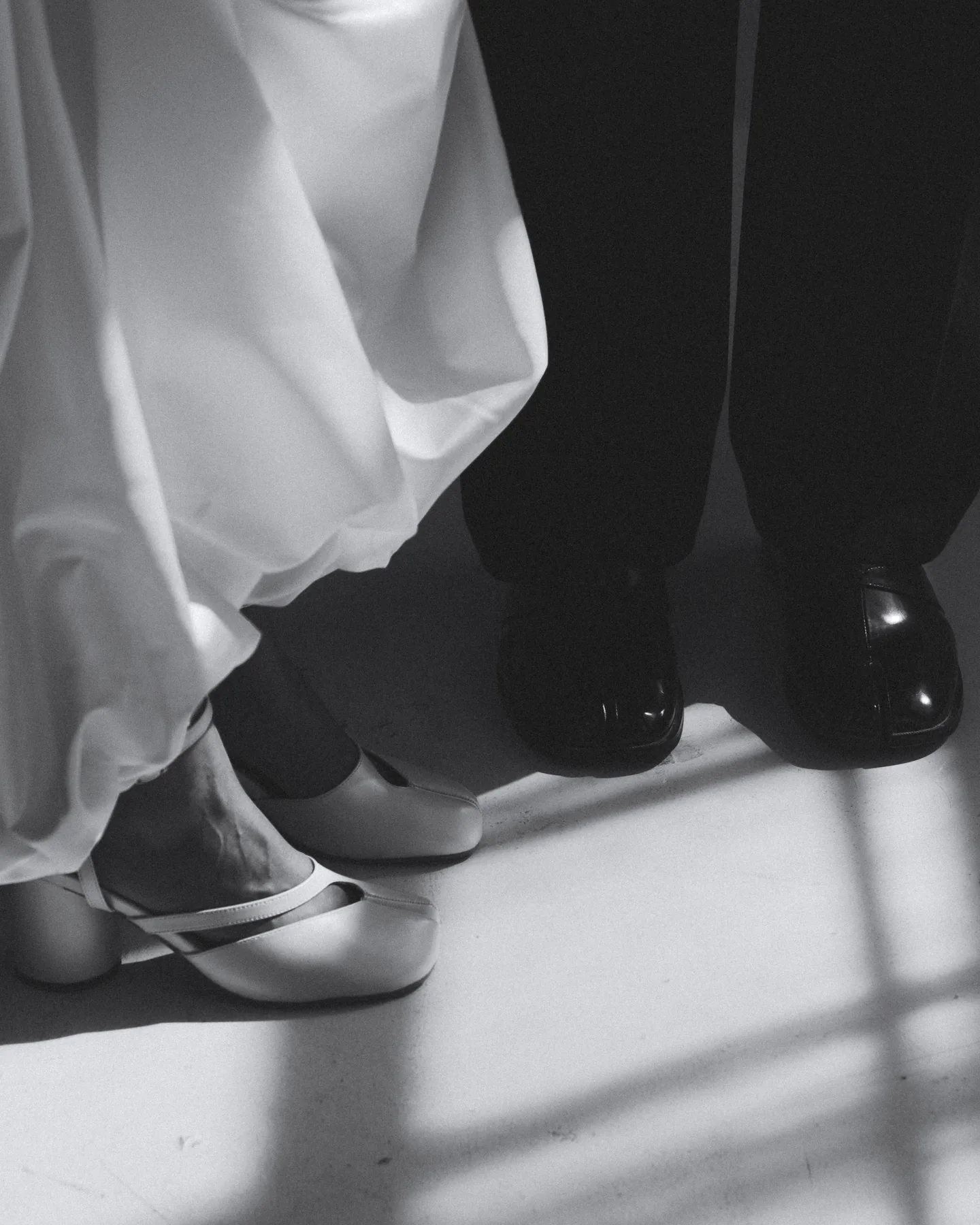 Bride and groom standing close together in formal shoes