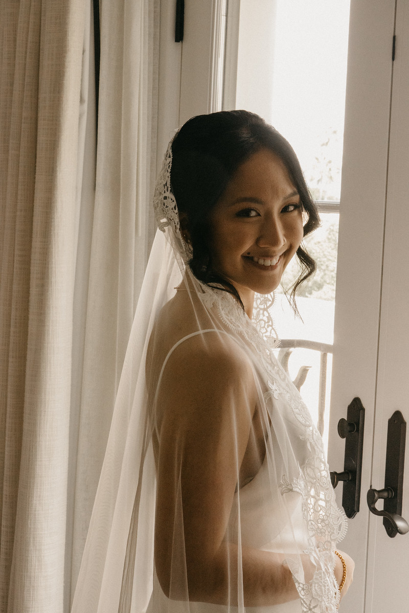 Bride smiling in window light